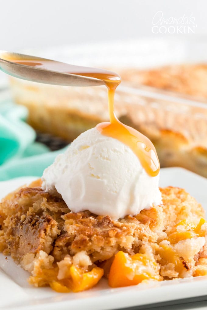 spoon dripping caramel onto ice cream on peach cobbler dump cake