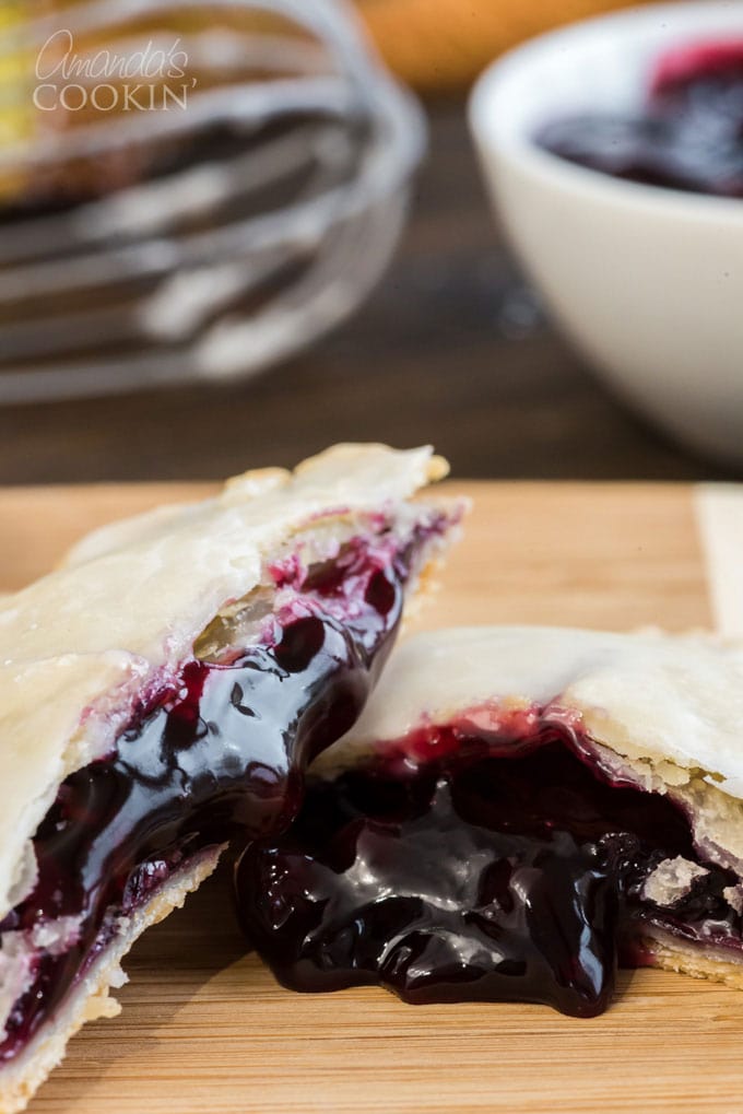 hand pie broken in half with blueberry filling coming out