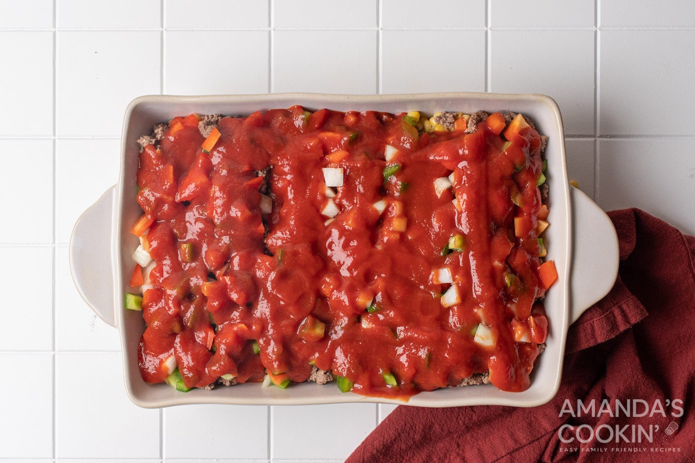pasta sauce over veggies in a baking dish