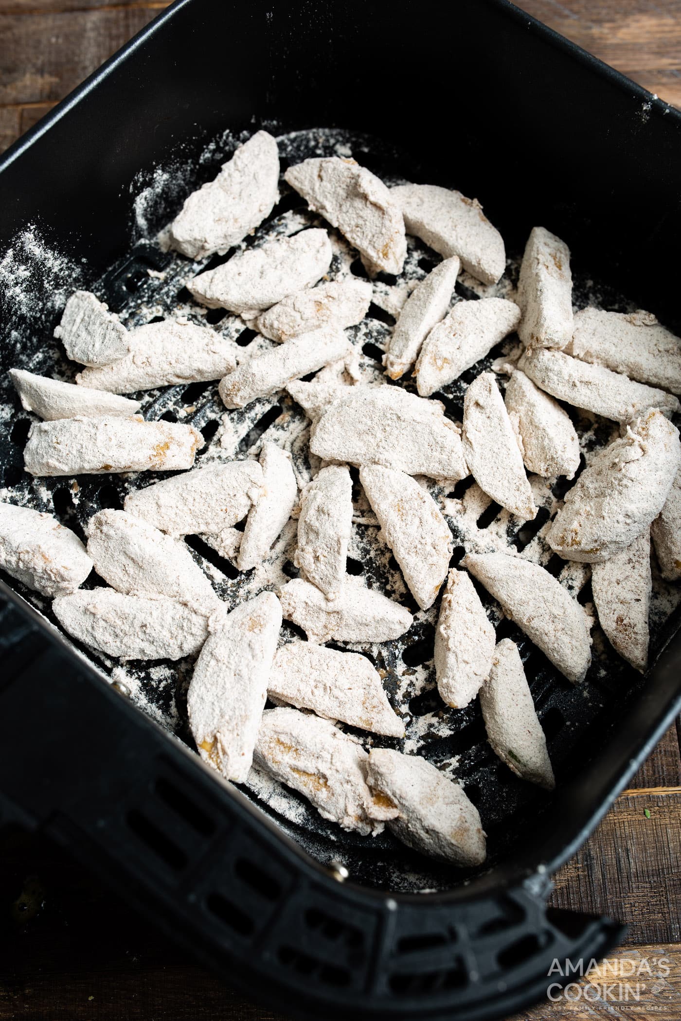 floured apple slices in air fryer basket