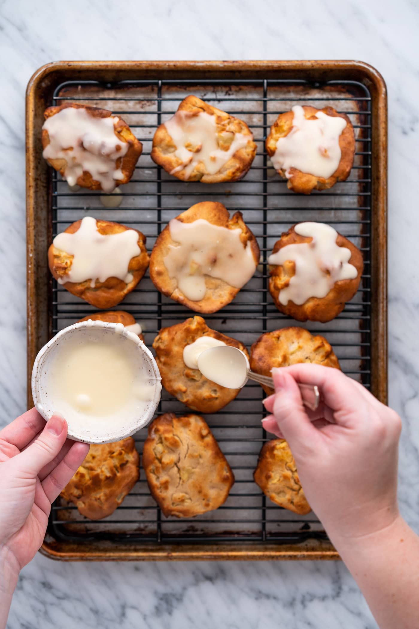 spooning glaze over apple fritters