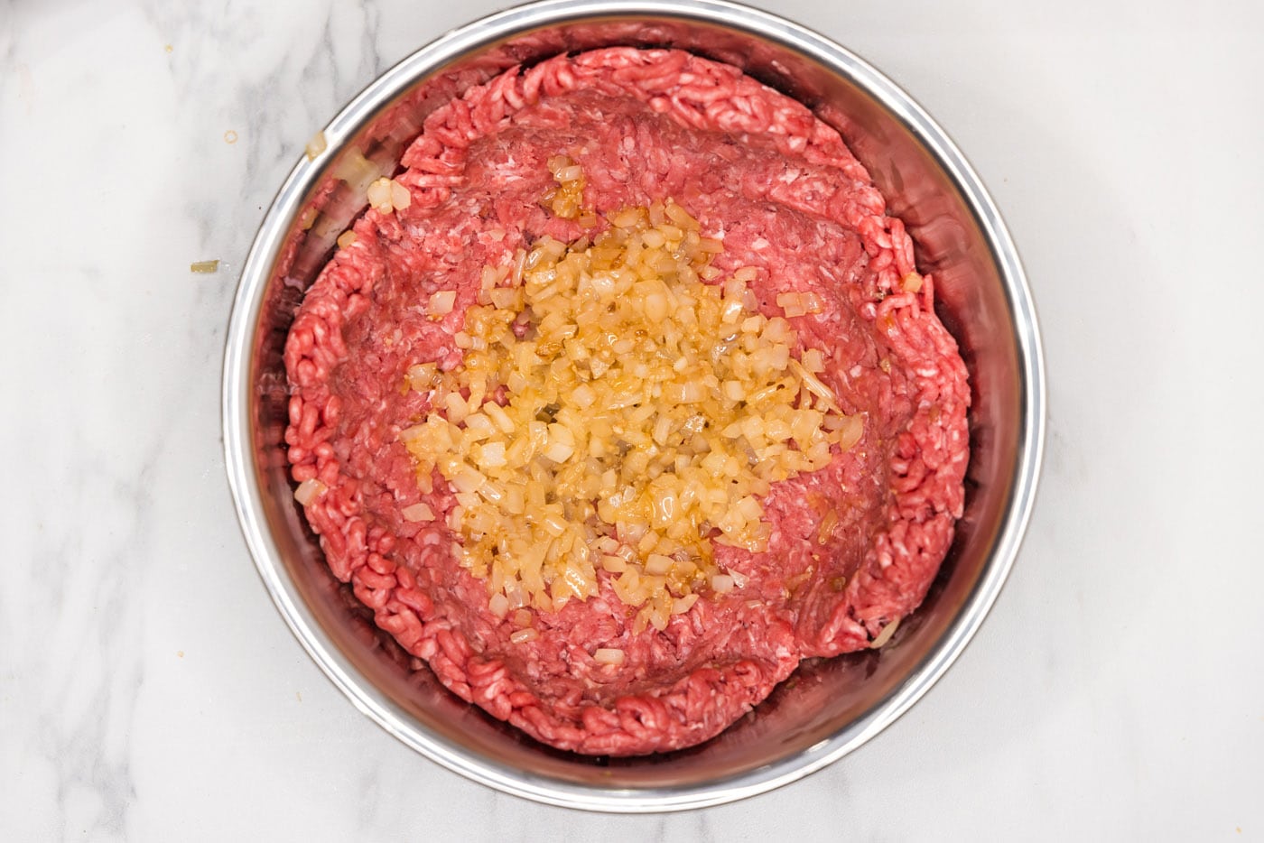 adding sauteed onion and garlic to ground beef