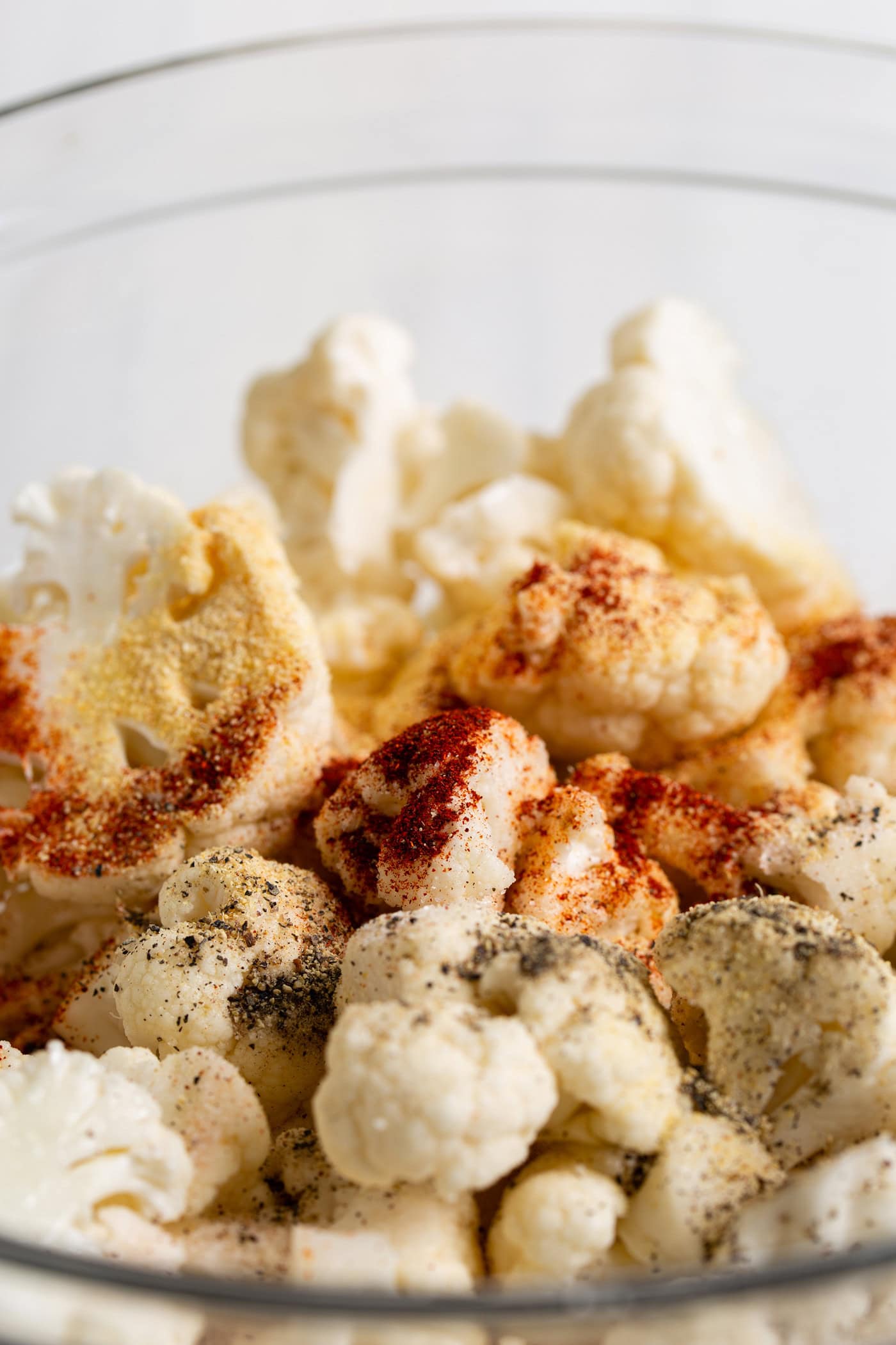 Seasonings sprinkled over a bowl of cauliflower