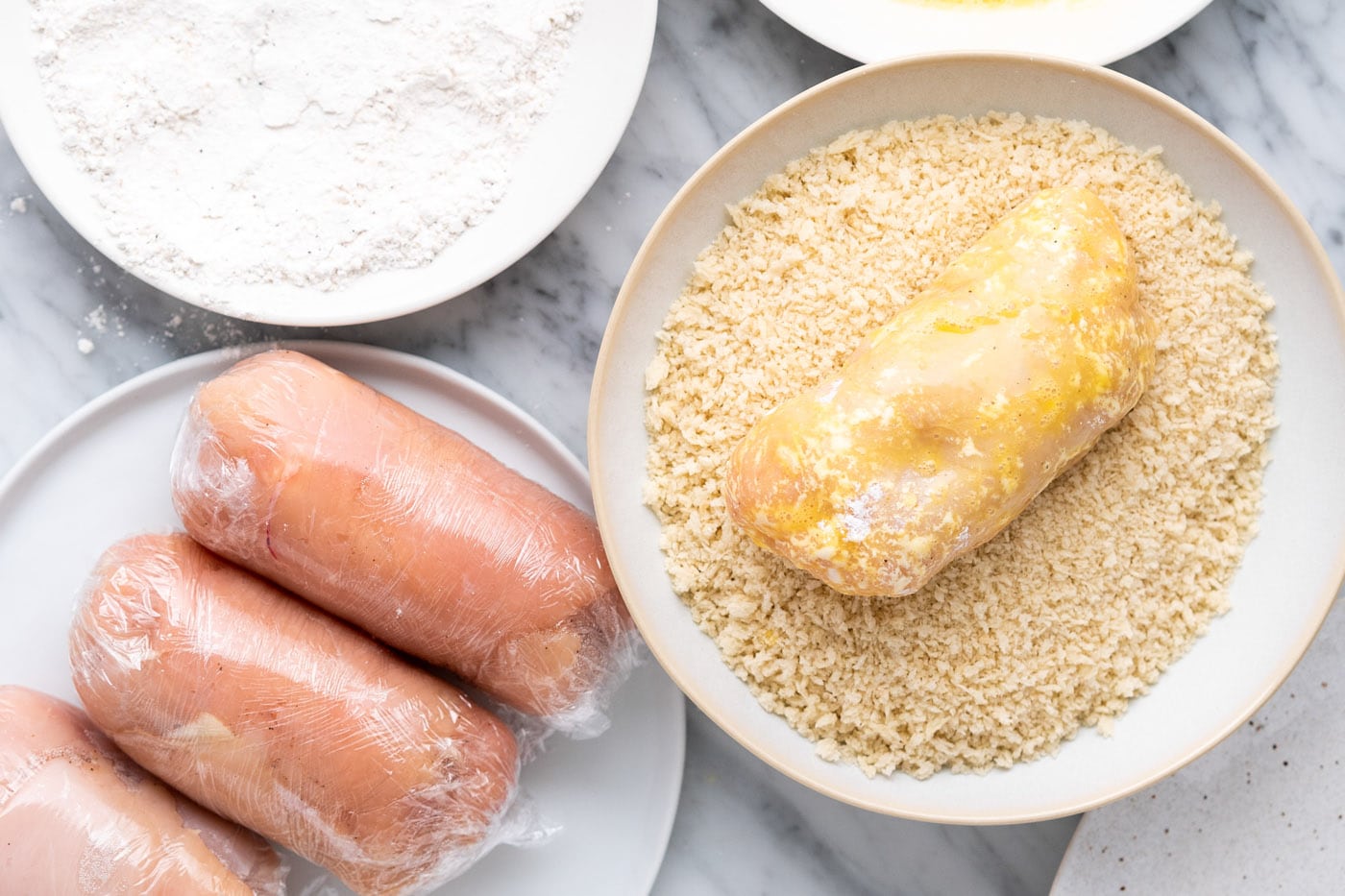 rolling chicken cordon bleu in breadcrumbs