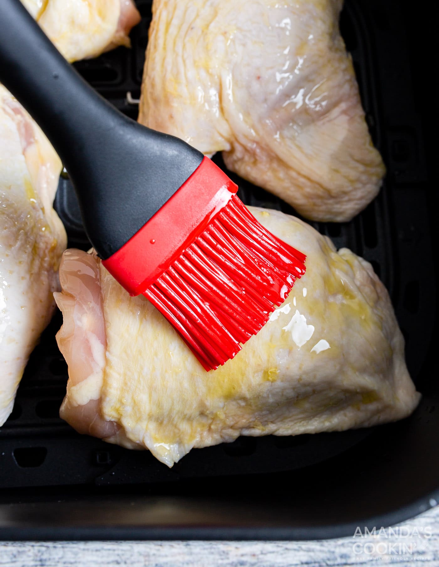 brushing chicken thighs with oil