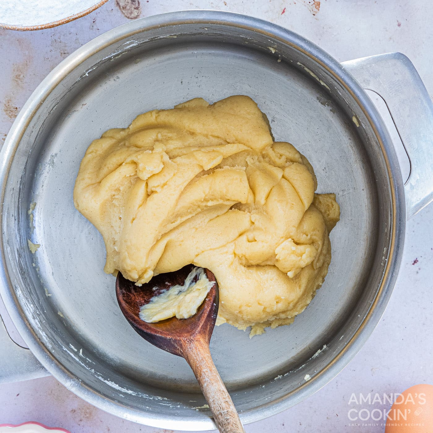 stirring dough with wooden spoon