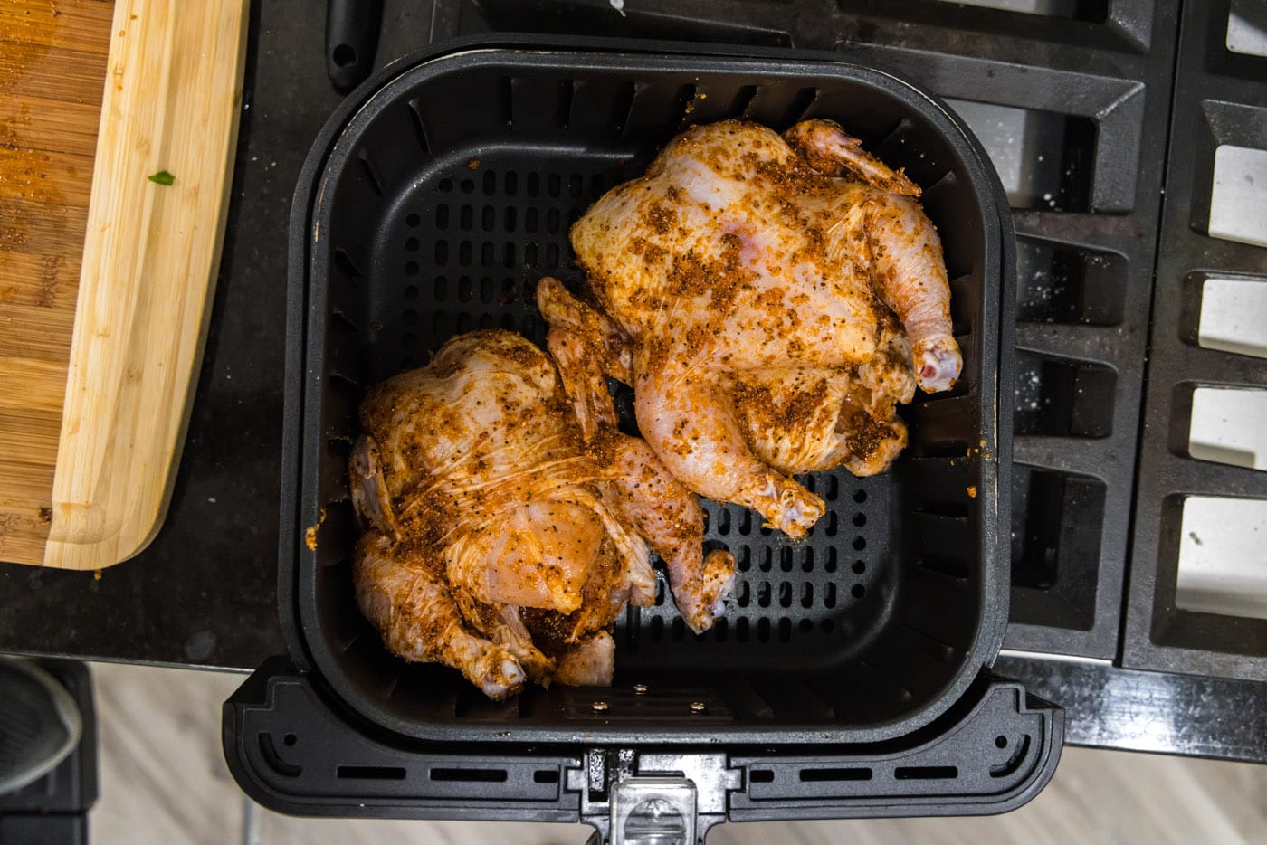 two cornish hens in an air fryer basket