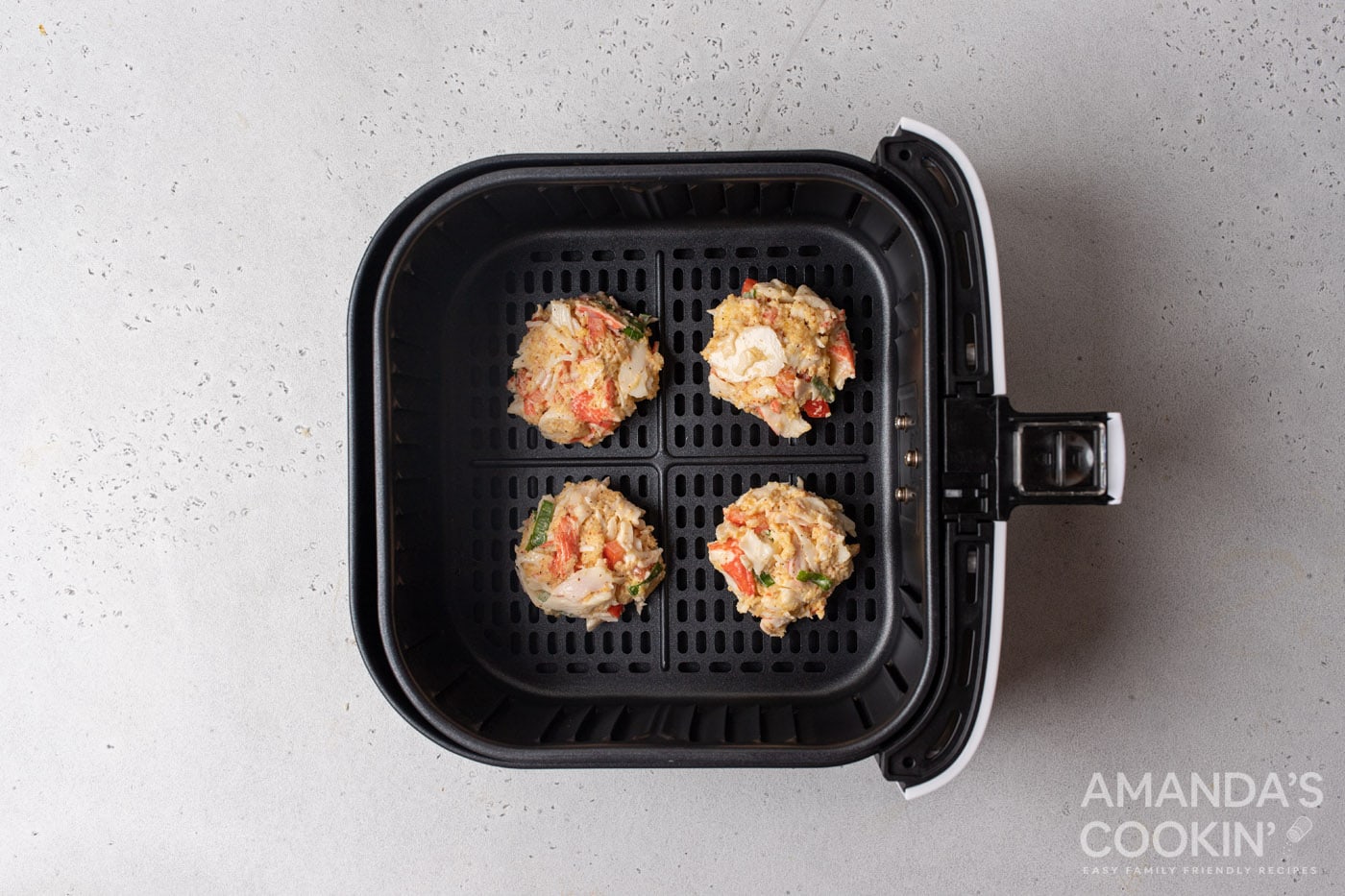 crab cake patties in an air fryer basket