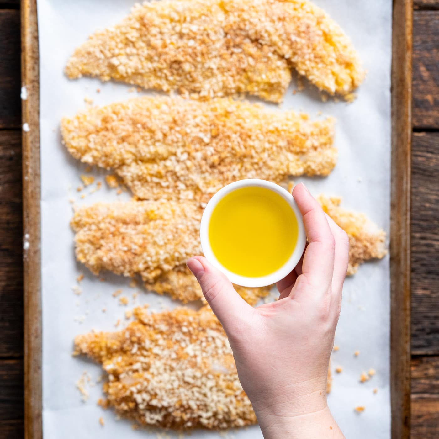 drizzling olive oil over fish fillets