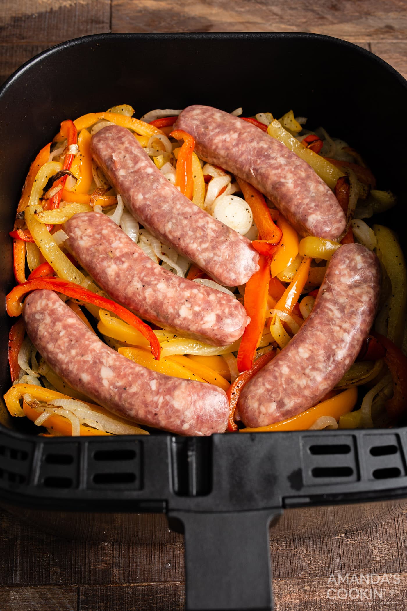sausage and peppers in an air fryer basket