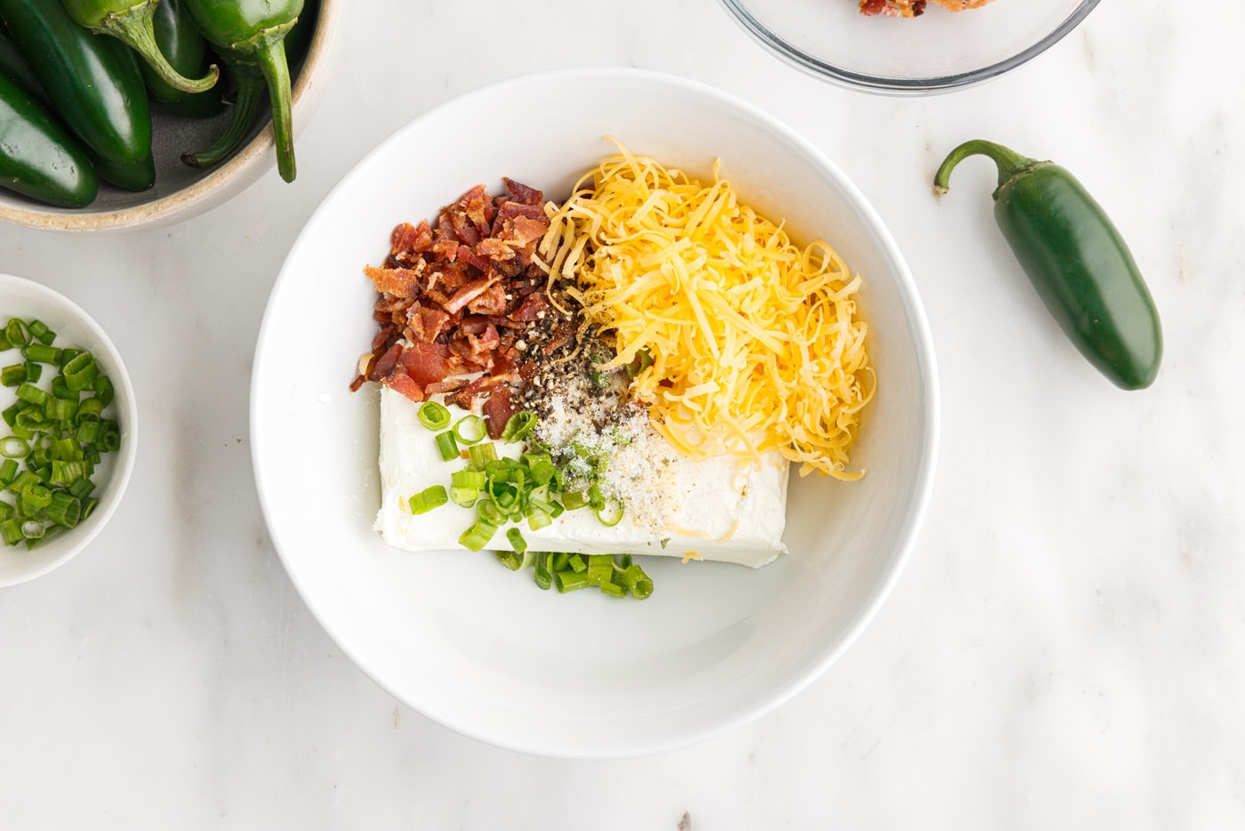 crumbled bacon, cream cheese, cheddar cheese, green onion, and seasonings in a bowl