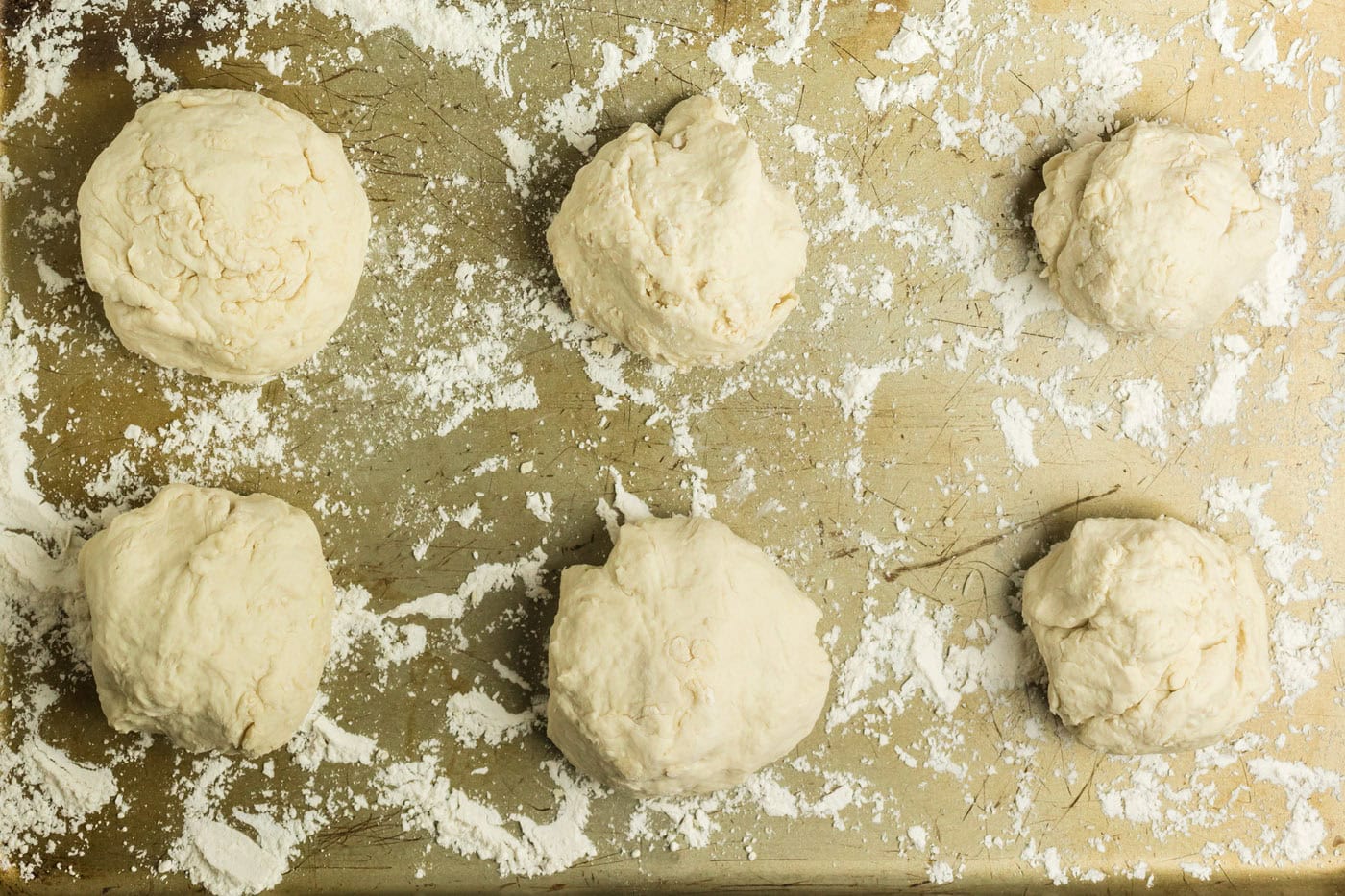 Floured cookie sheet with 6 dough pieces on it