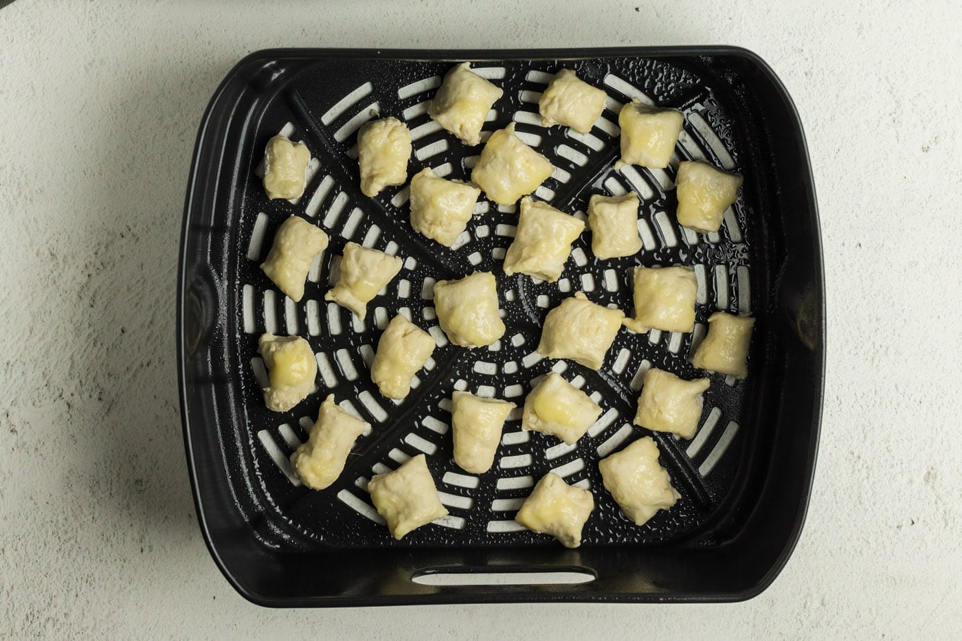 Pretzel dough bites in an air fryer basket