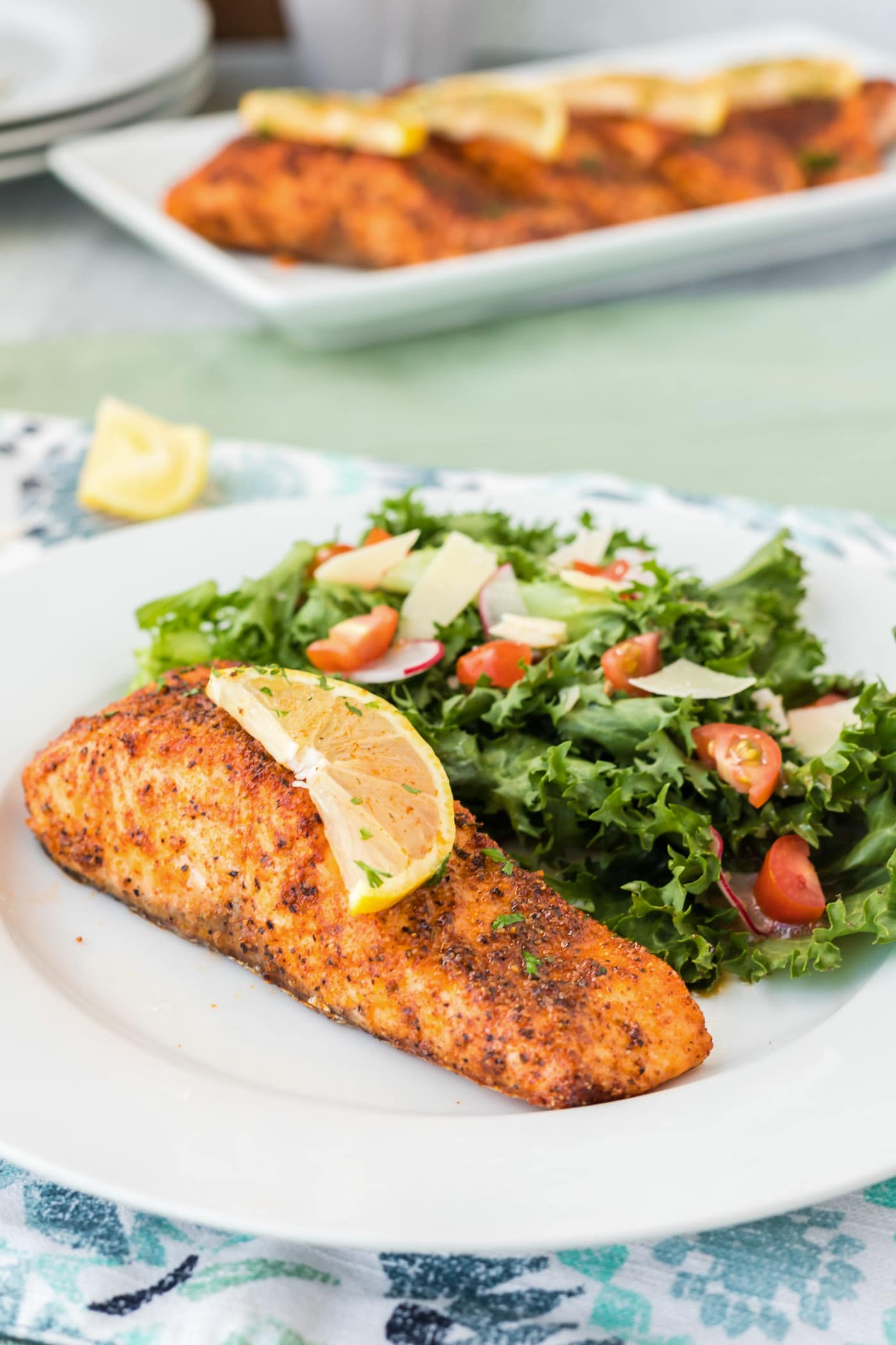 Air Fryer Salmon on a plate with a slice of lemon on top