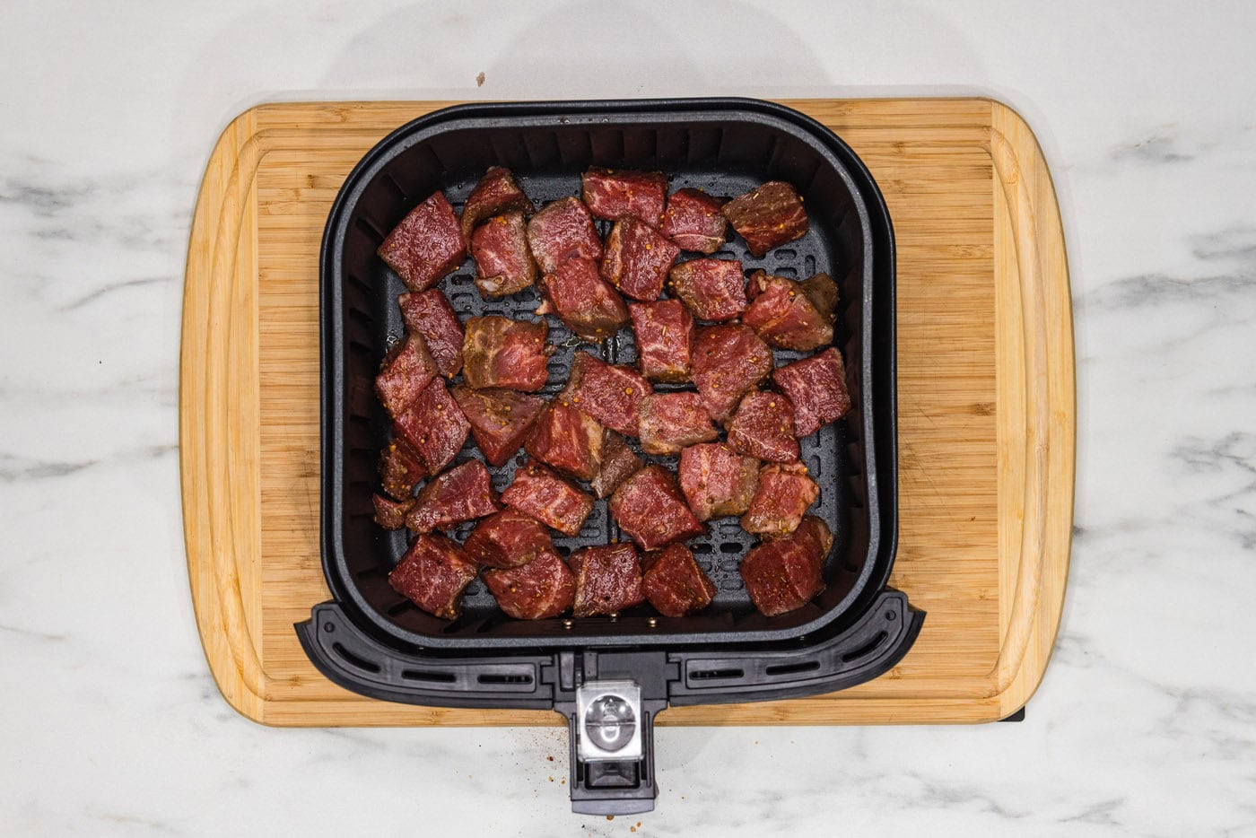 steak bites in an air fryer basket