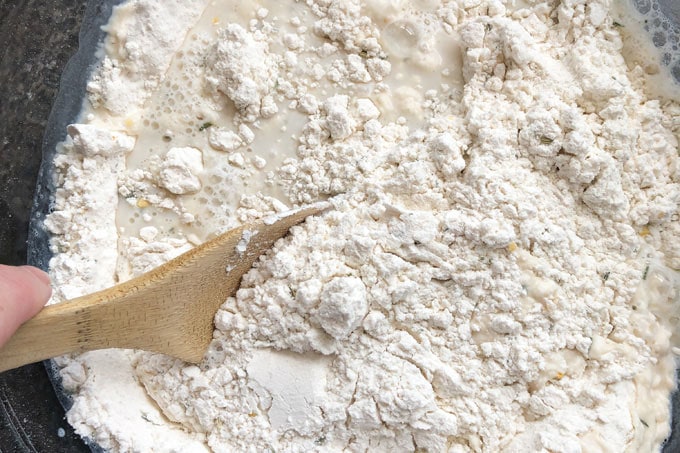 stirring flour with water and milk in a bowl