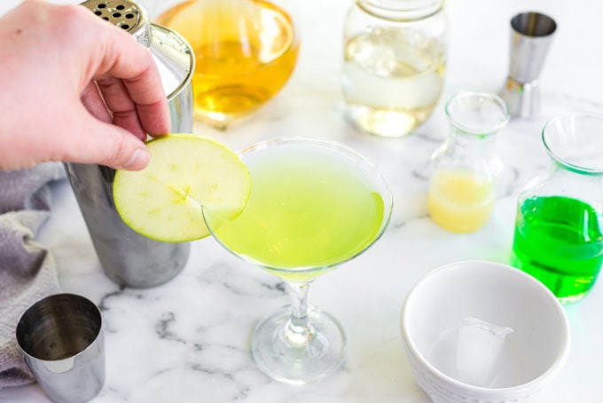 placing apple wheel slice on edge of martini glass