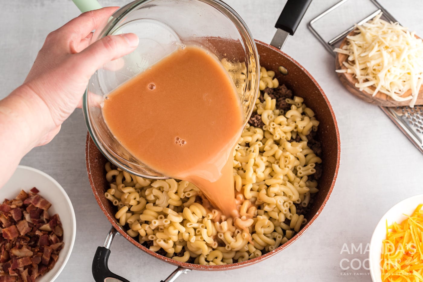 adding broth to skillet with pasta and ground beef