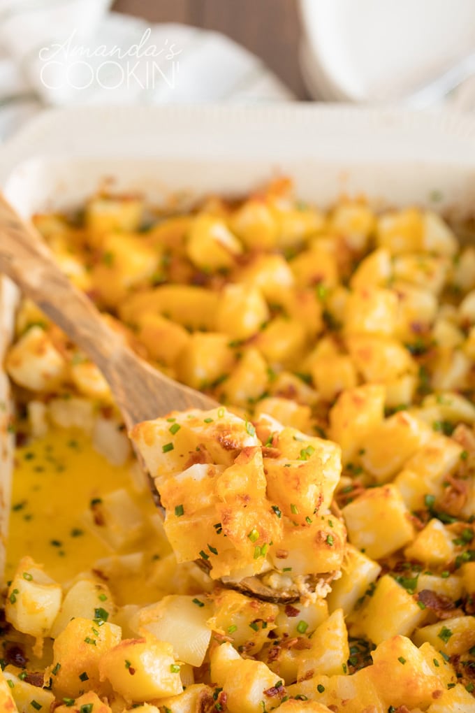 wooden spoon dipped in cheese potatoes casserole