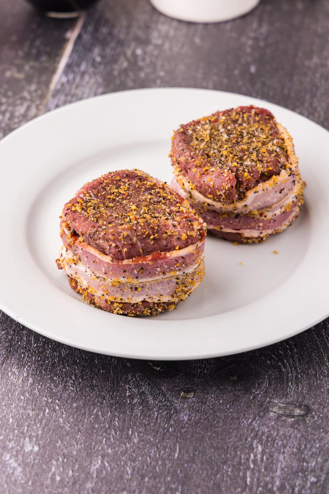 bacon wrapped around filet mignon on a plate