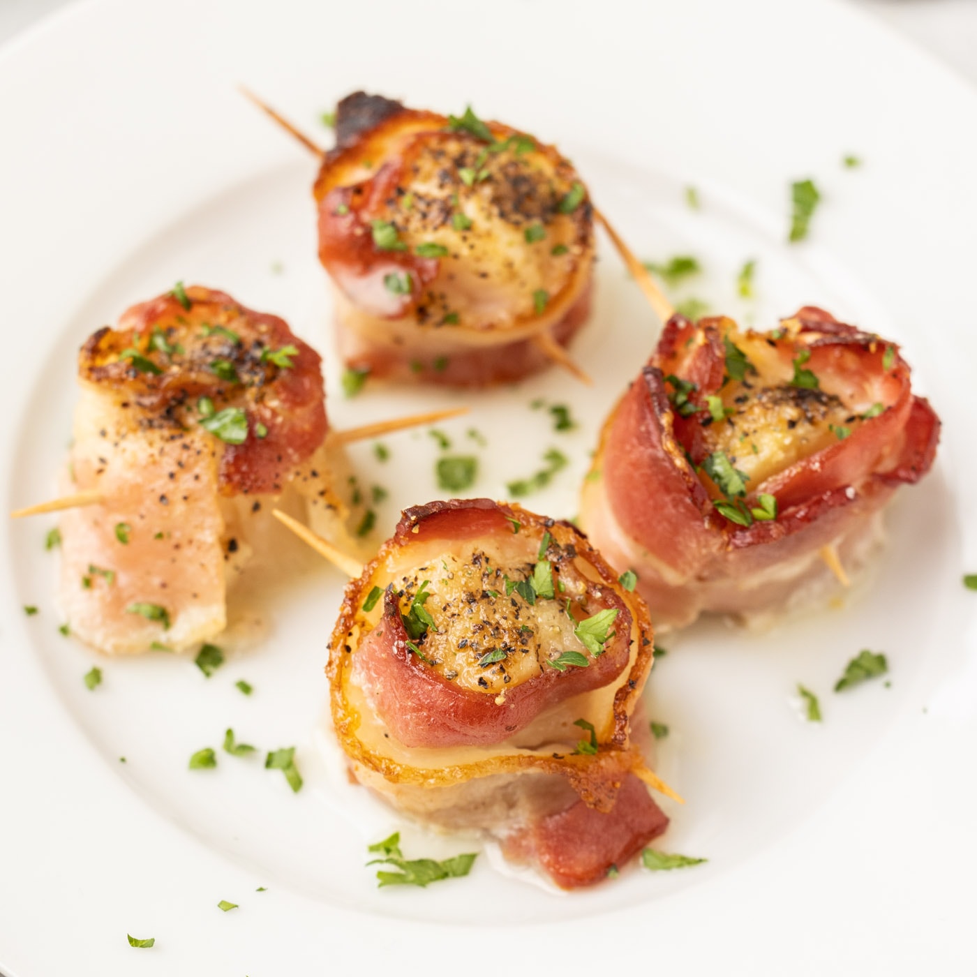 Bacon Wrapped Scallops on a white plate