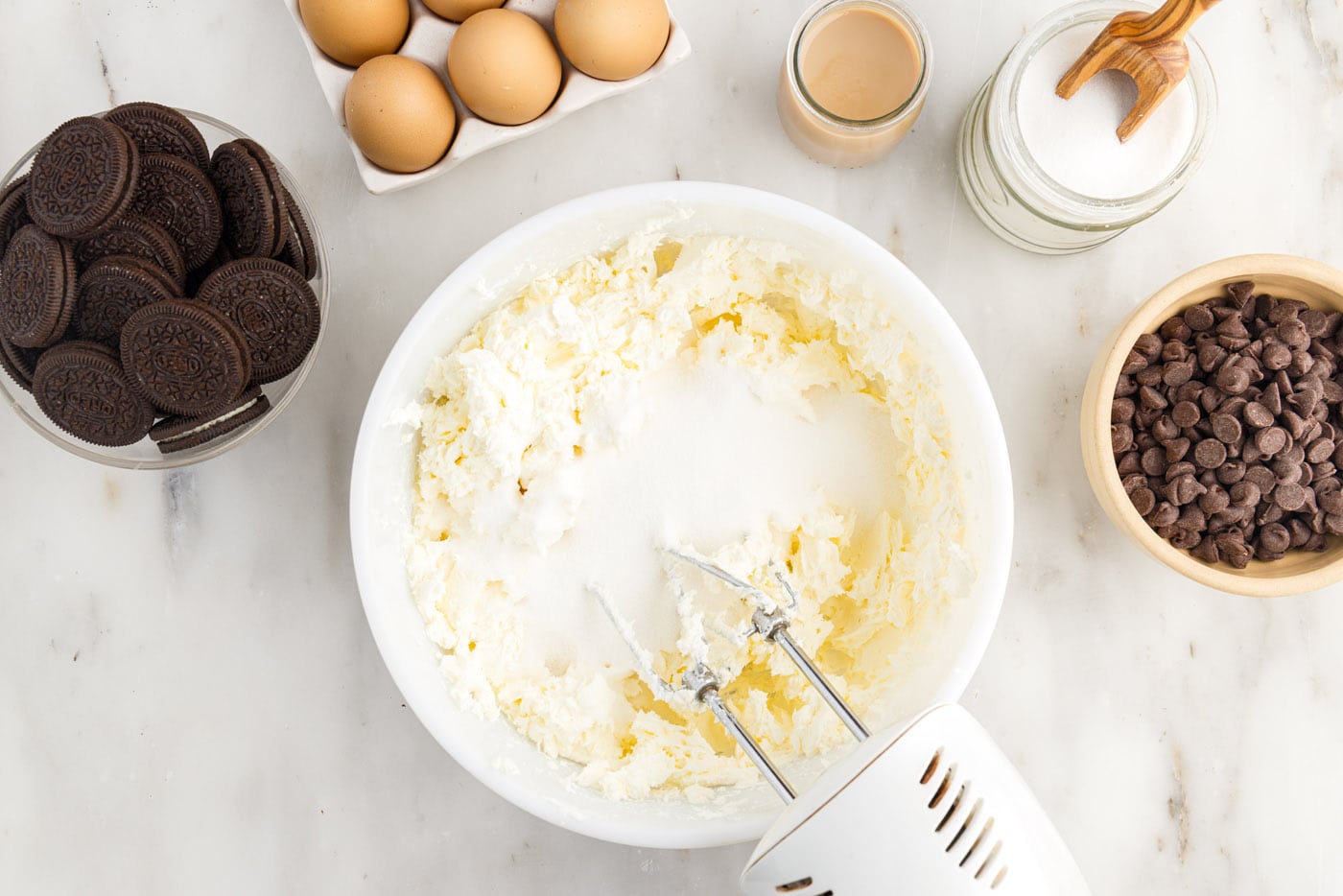 blending cream cheese with sugar with a mixer