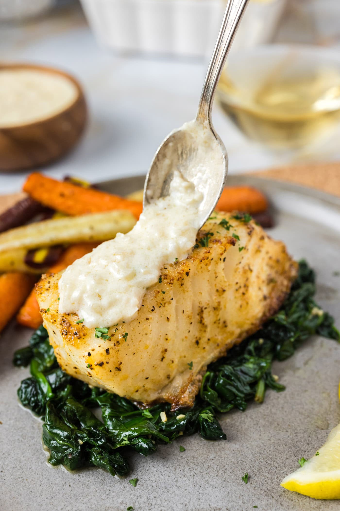 Beurre Blanc Sauce being spooned over Baked Chilean Sea Bass