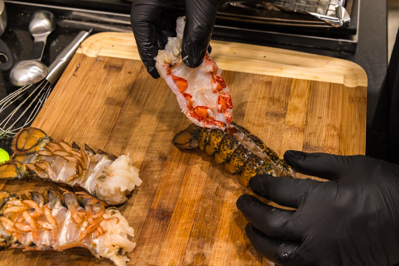 hand pulling lobster meat out of shell