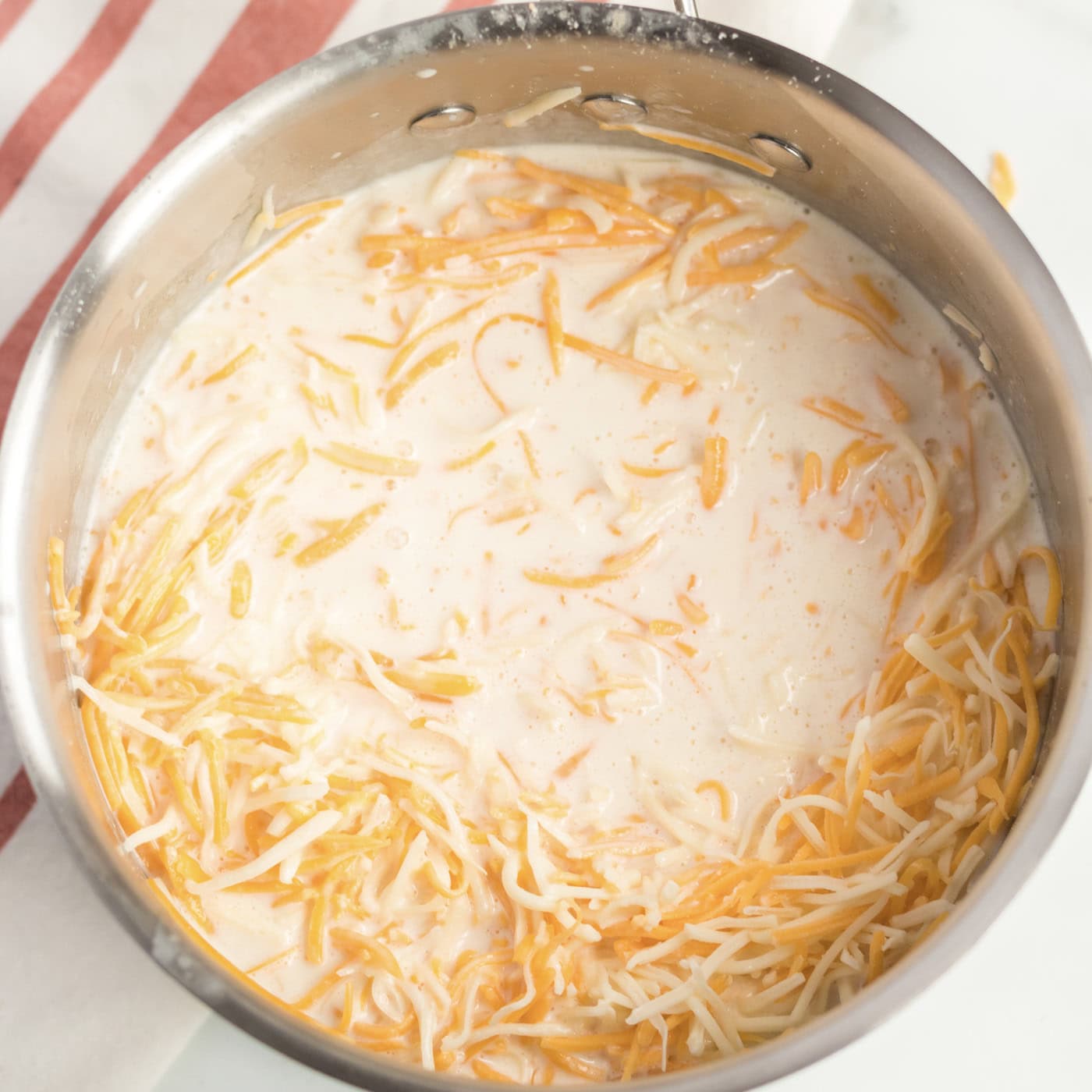 Cheese added to a saucepan of butter, flour, milk and cream