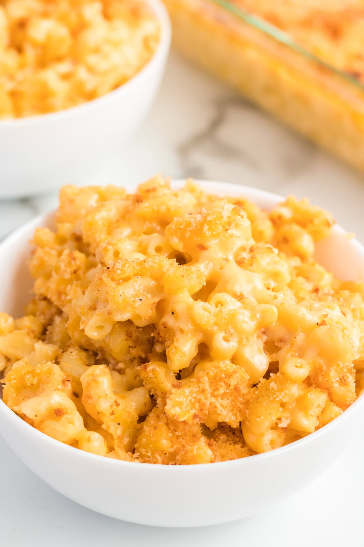 Bowl of Baked Macaroni and Cheese with another bowl behind it