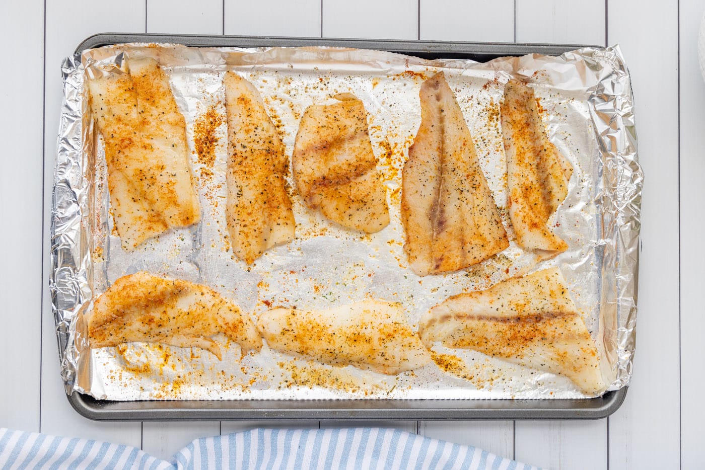 seasoned orange roughy on a baking sheet