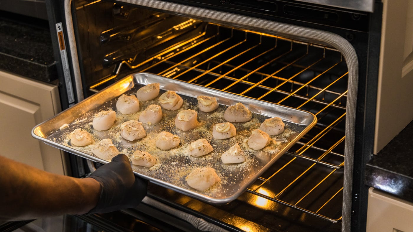placing scallops into oven to bake