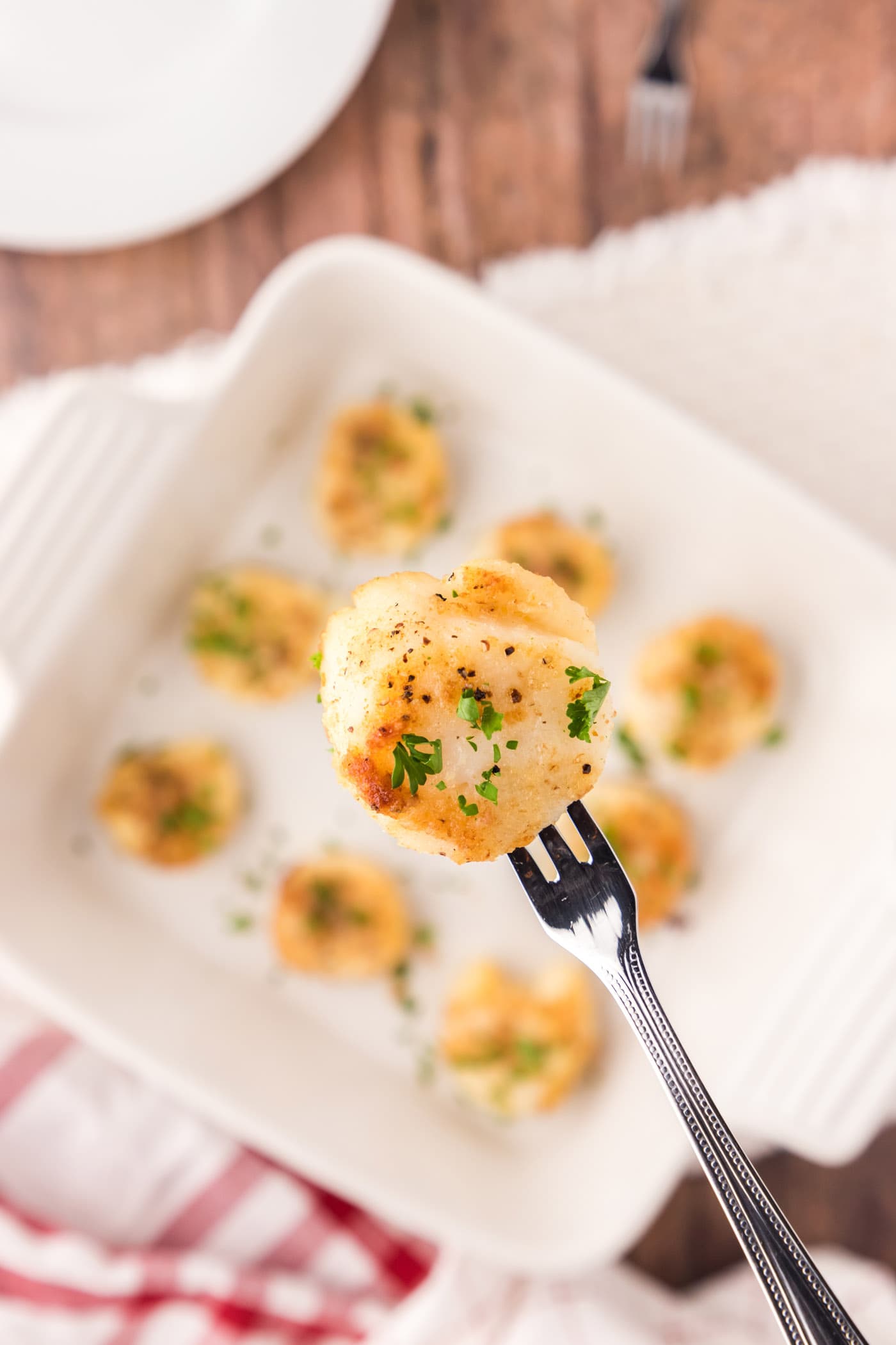 Close up of a Baked Scallop on a seafood fork