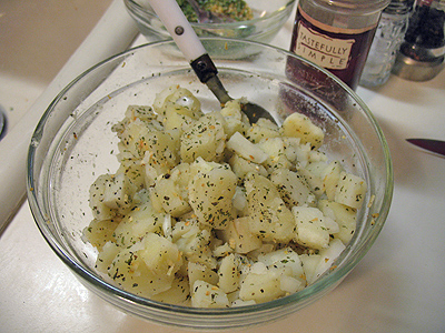A clear bowl filled with cubed potatoes.