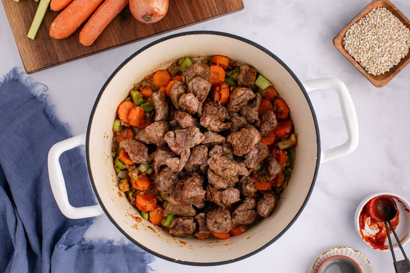beef stew meat added to soup pot with vegetables