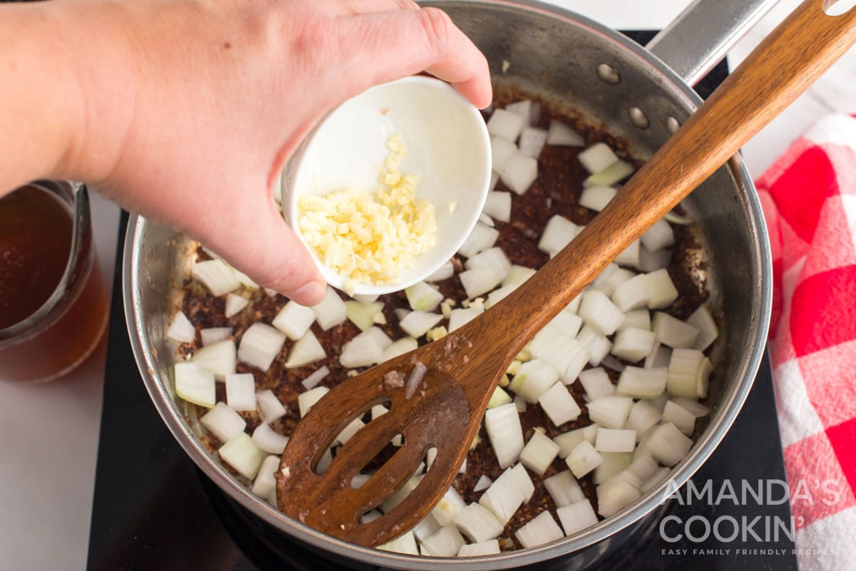 adding garlic to pan