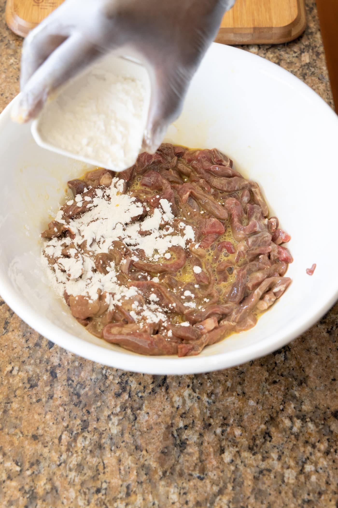 adding cornstarch to egg and beef mixture in a bowl