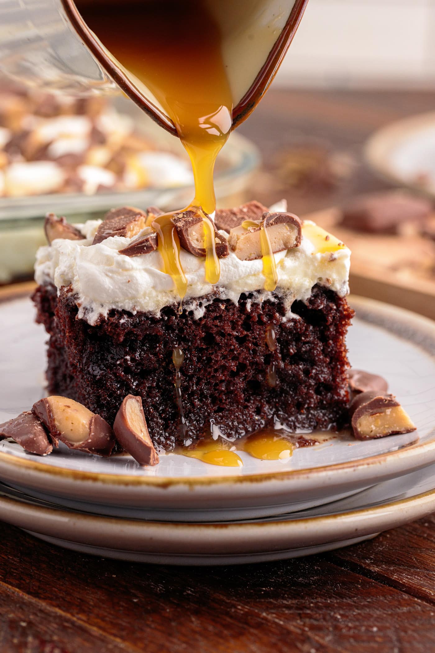 Caramel being drizzled over a piece of Better Than Sex Cake