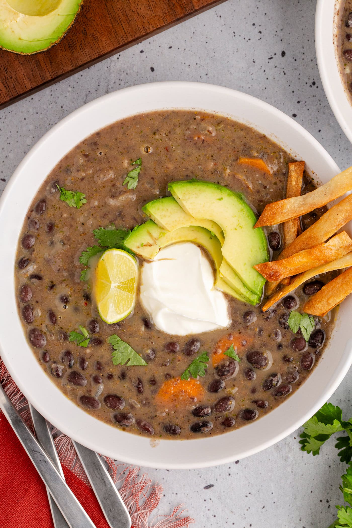 Bowl of Black Bean Soup topped with sour cream and avocado
