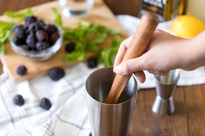 muddling cocktail ingredients in a shaker