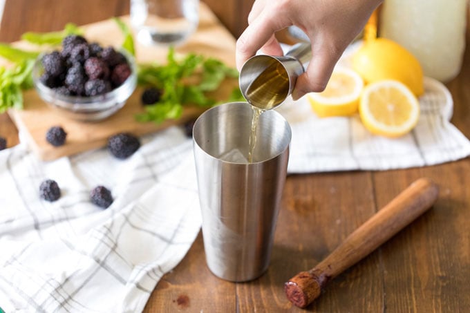 adding bourbon whiskey to cocktail shaker