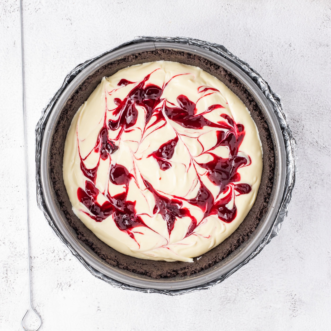 swirled blackberry reduction on top of cheesecake batter