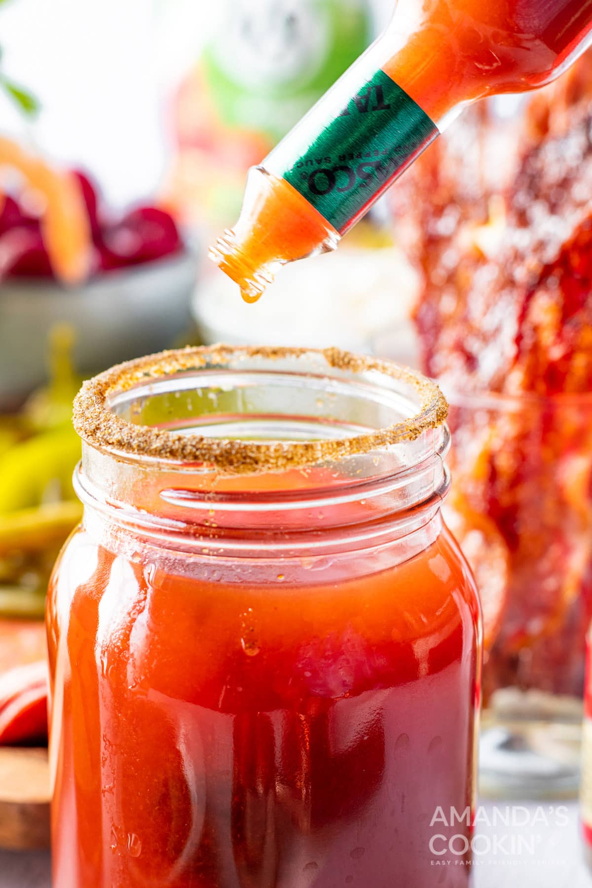 adding hot sauce to glass