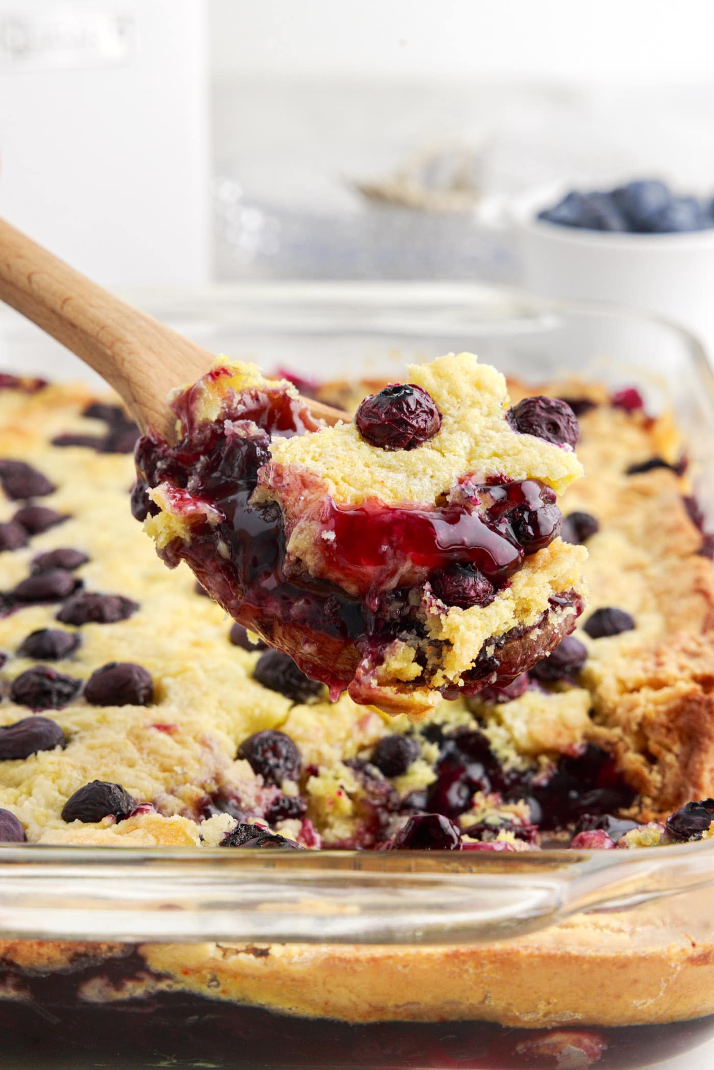 Spoonful of Blueberry Dump Cake being lifted out of the pan