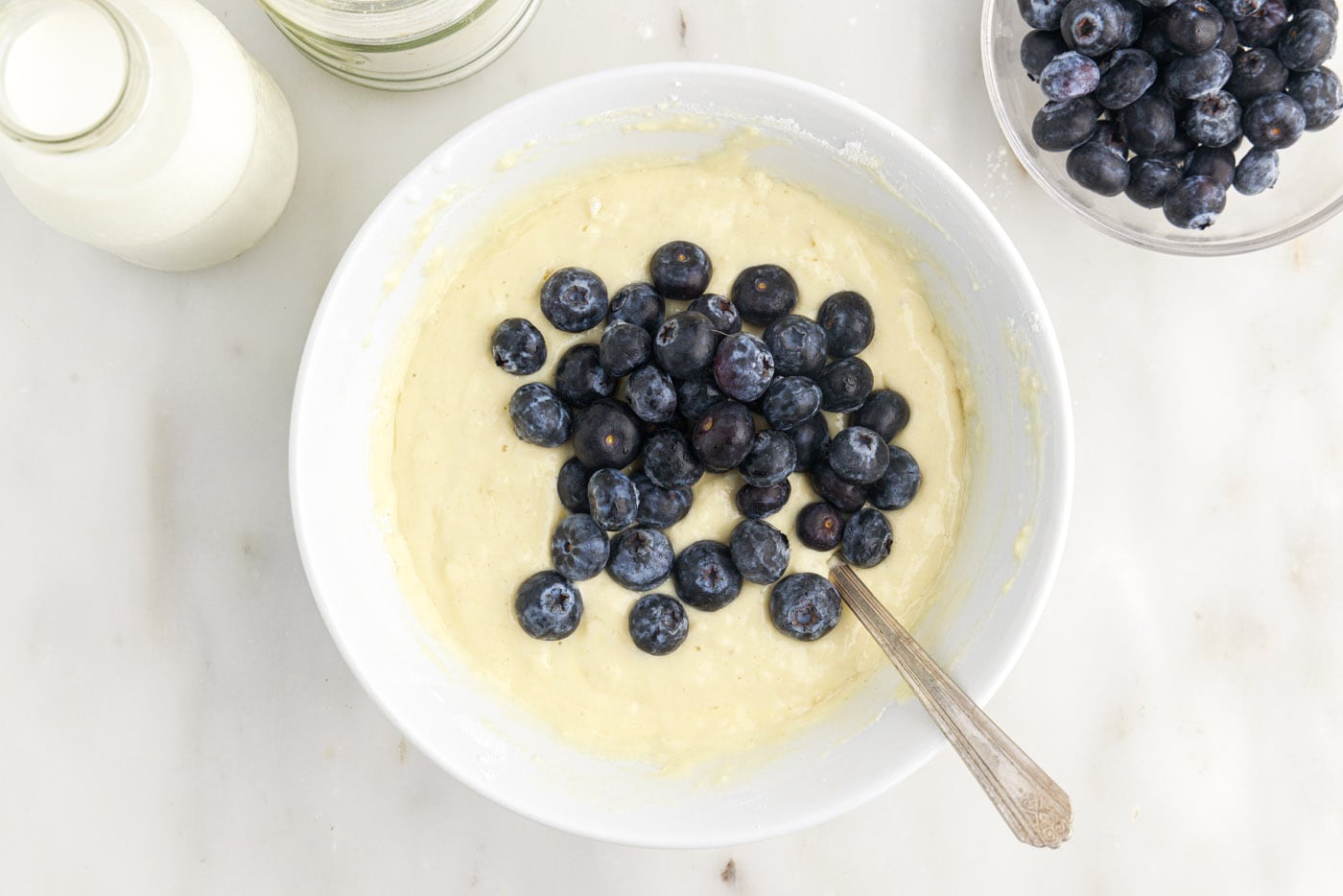 folding fresh blueberries into pancake batter