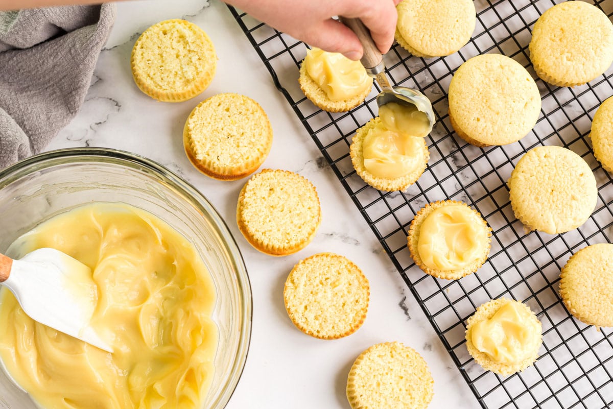 spooning pudding onto a sliced cupcake