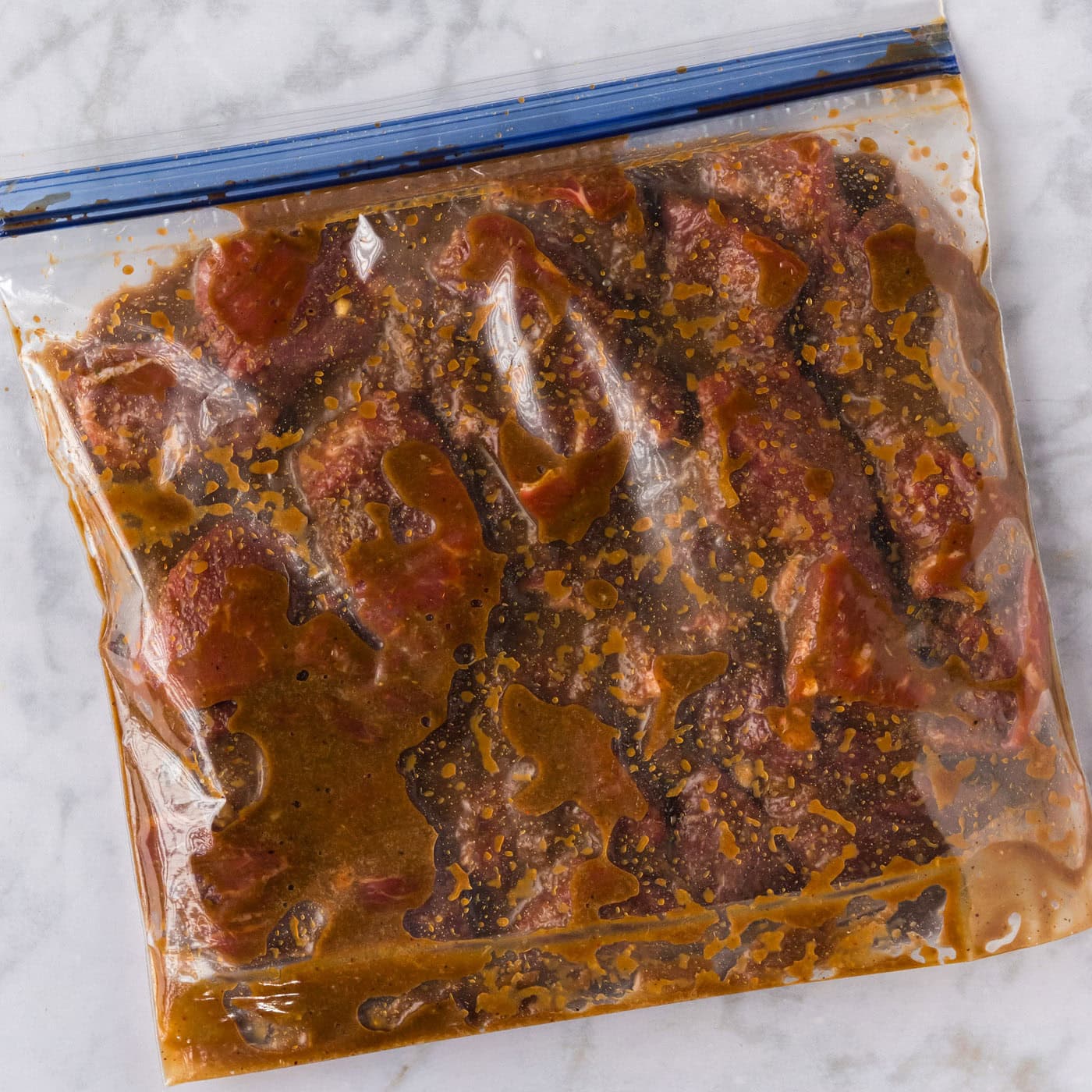 Close up photo of steak and Bourbon Marinade in a ziptop bag