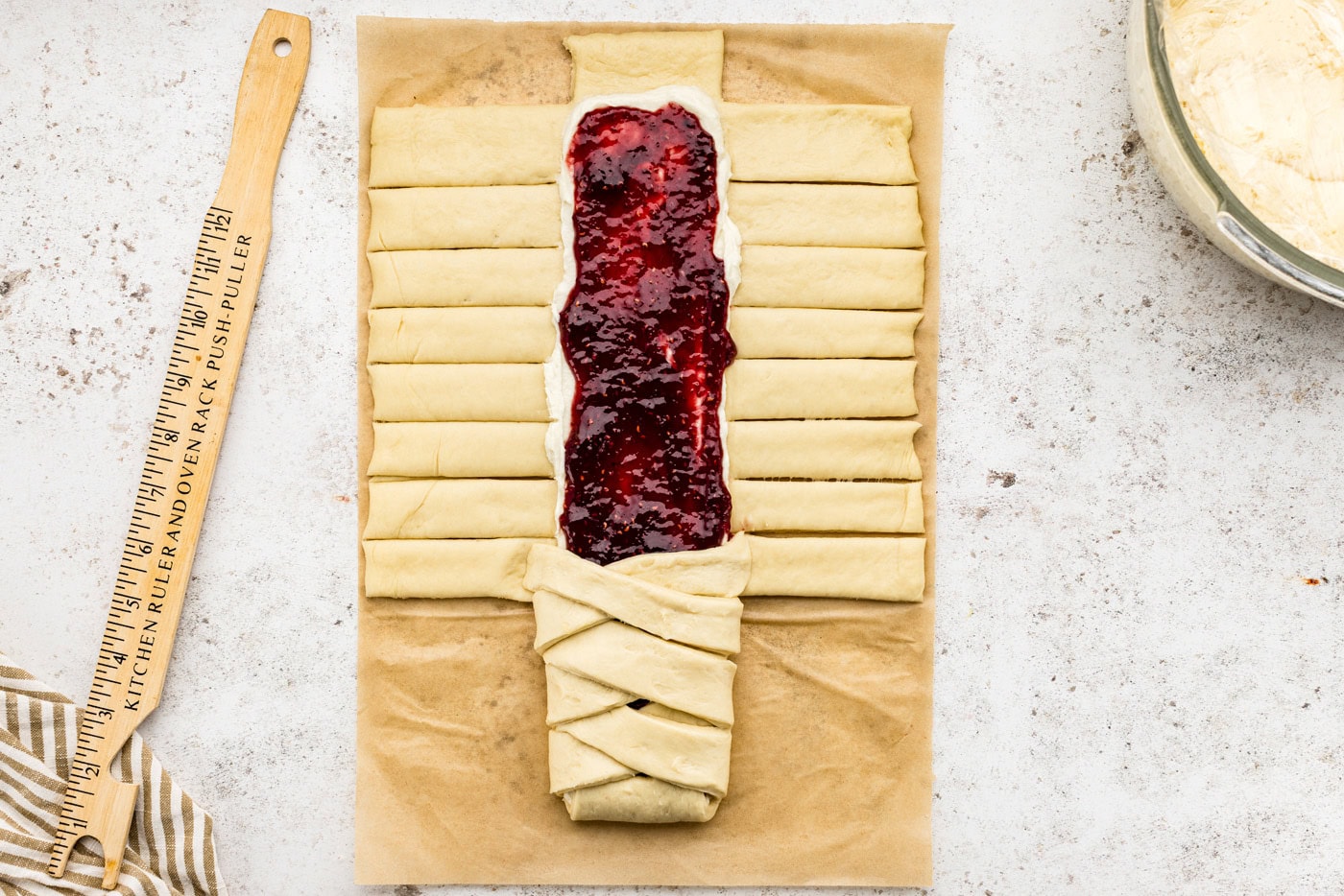 folding dough strips overtop the filling