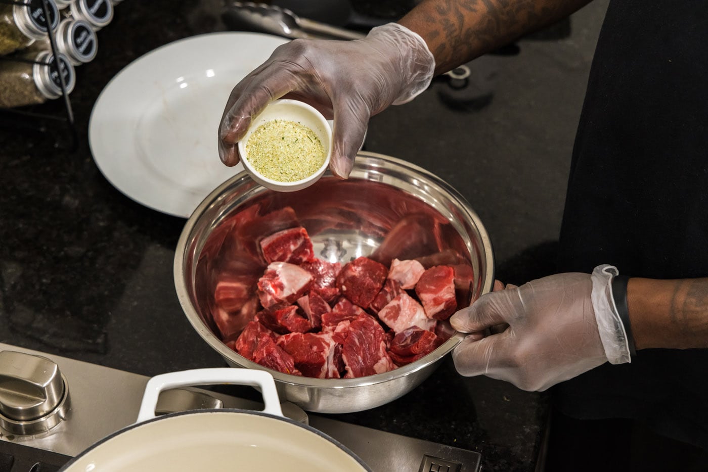 adding garlic salt to cubed chuck roast