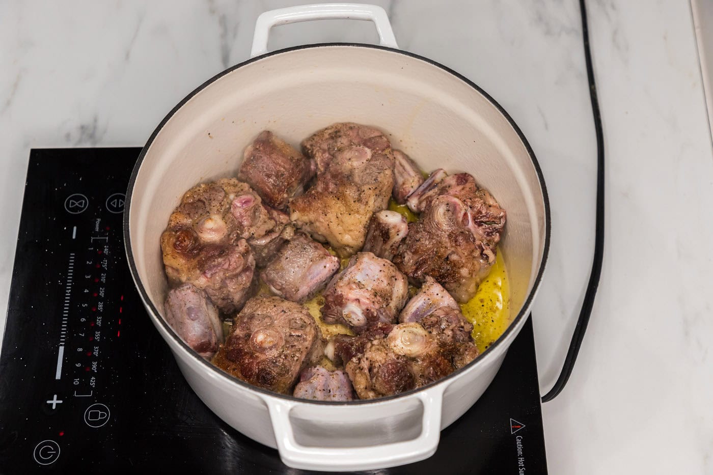 browned oxtail in a dutch oven before braising